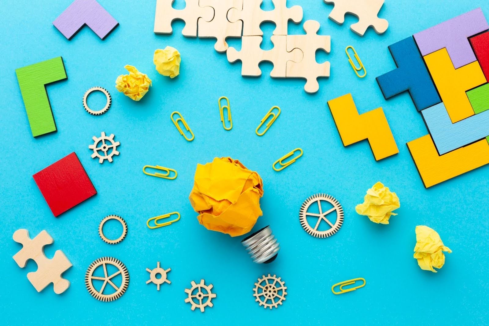 Лампочка и пазлы на голубом фоне — символ развития soft skills и гибкого мышления